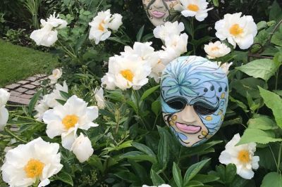 Venezianische Masken inmitten von weißen Paeonien